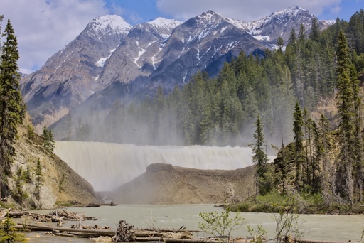 Wapta falls form its lowest viewpoint along the Kicking Horse River.  Aquila mountain and surrounding peaks may be seen rising in the distance.